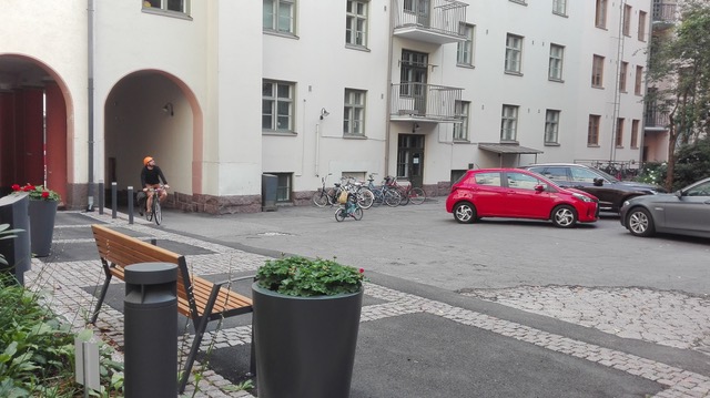 Bilar och cyklar parkerade på höghusgården